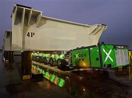 green trailers in NXGEN colours under a white steel oversize load