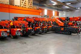 Completed orange Jekko mini cranes lined up at the end of the production line