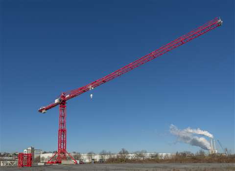 Red low top tower crane against bright blue sky