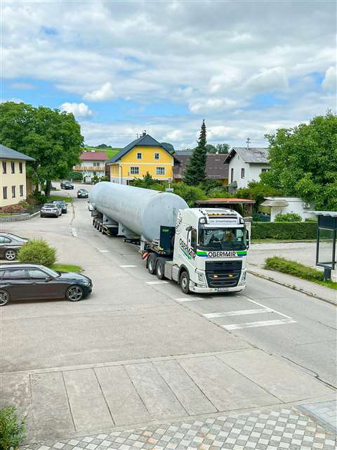 grey tank on a white truck in a village